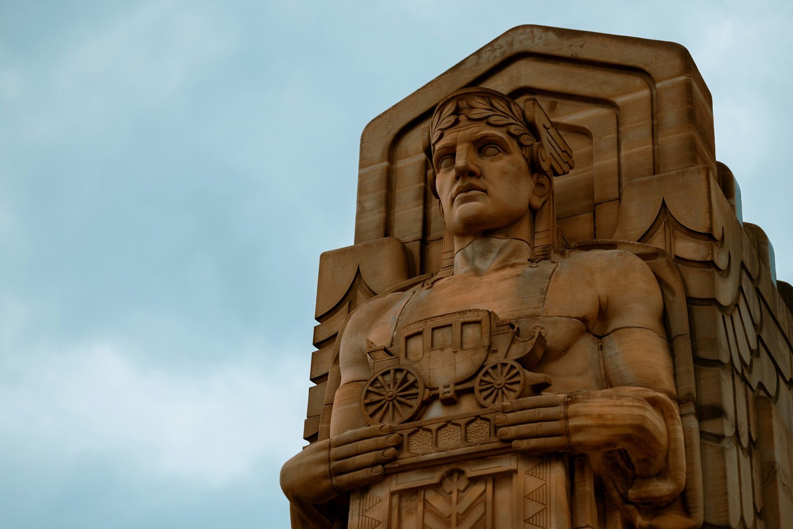 a statue of a man holding a shield on top of a building